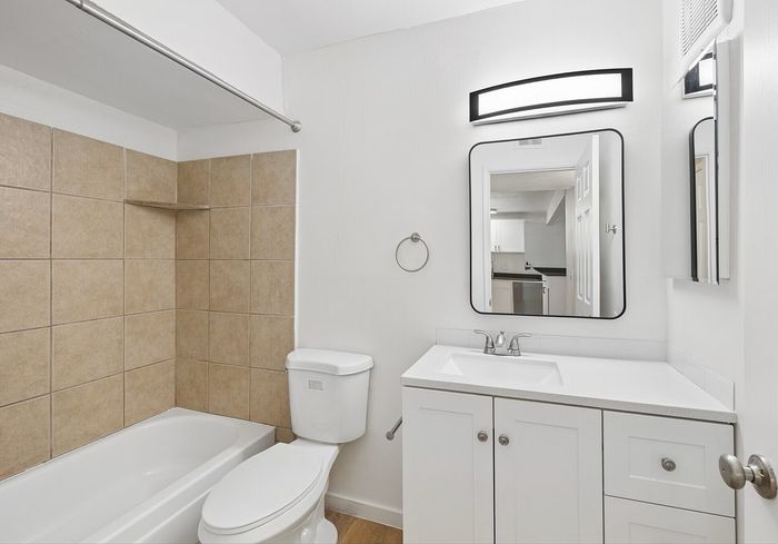 Modern bathroom with tiled bathtub, fixtures and vanity mirror at Miramonte on 3rd in Tucson, AZ