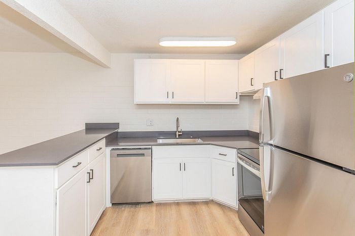 Modern kitchen with sleek stainless steel appliances, crisp white cabinetry, and polished countertops, offering a fresh and inviting space.