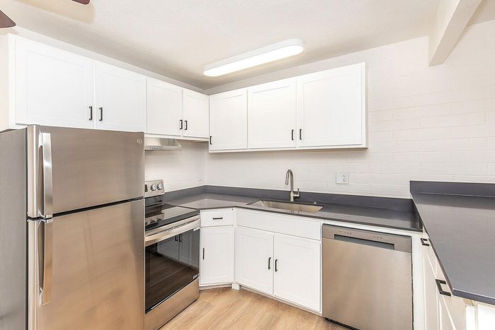 Modern kitchen with sleek stainless steel appliances, white cabinetry, and elegant countertops.