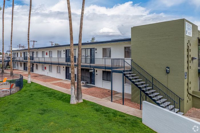 Elegant two-story apartment complex with spacious balconies and lush greenery, perfect for comfortable living.