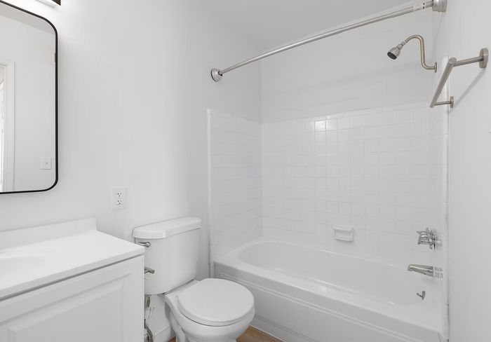 Bright, modern bathroom with a clean white design featuring a spacious bathtub and sleek fixtures.