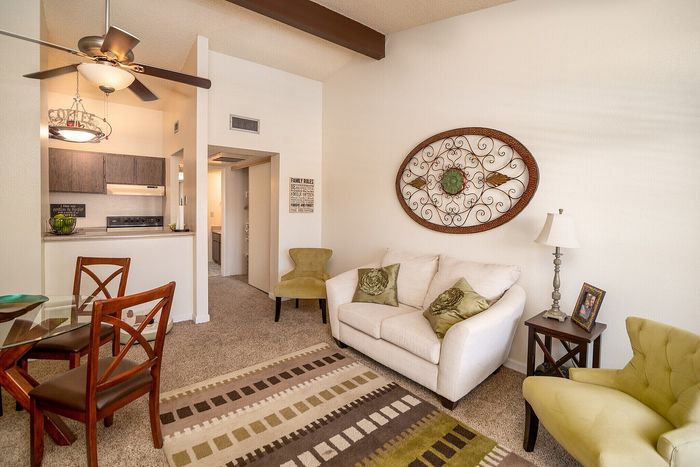 Inviting living space with neutral walls, stylish decor, and cozy seating area next to a charming dining nook.