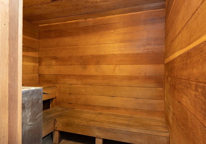 Cozy and inviting wooden sauna with warm tones, perfect for relaxation and unwinding.