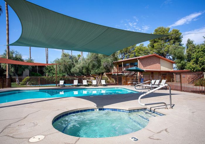 Inviting swimming pool area with sun loungers and vibrant greenery, perfect for relaxation and leisure.