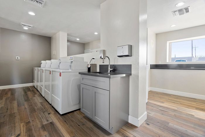 Modern laundry room with sleek appliances, spacious countertop, and elegant flooring, offering convenience and style.