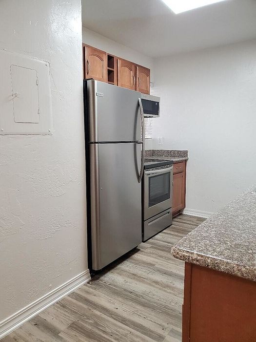 Modern kitchen with sleek stainless steel appliances, elegant wood cabinetry, and chic granite countertops.