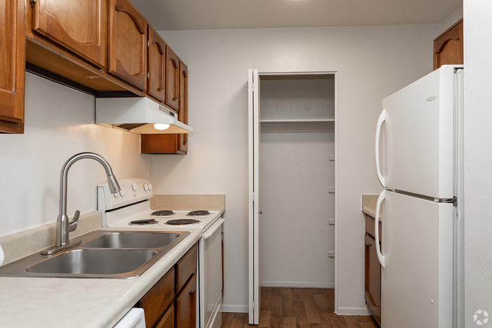 Charming kitchen with wooden cabinets, sleek countertops, and modern appliances, ideal for culinary enthusiasts.