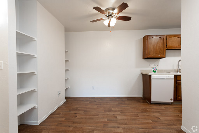 Inviting apartment space with rich wooden flooring, elegant ceiling fan, and modern kitchen cabinetry featuring convenient open shelving.