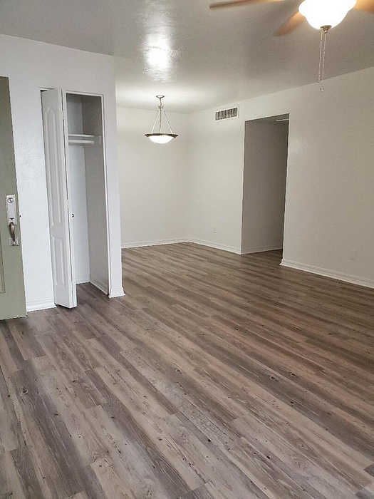 Bright apartment interior featuring modern laminate flooring, ceiling fan, and elegant lighting, perfect for a stylish urban lifestyle.