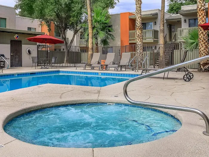 Beautiful apartment courtyard with lush green lawn, mature trees, picnic area, and charming pathway.