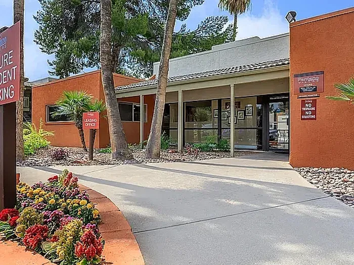 Beautiful apartment courtyard with lush green lawn, mature trees, picnic area, and charming pathway.
