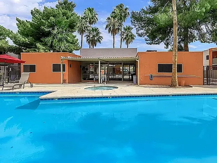 Beautiful apartment courtyard with lush green lawn, mature trees, picnic area, and charming pathway.