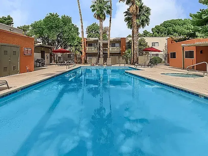 Beautiful apartment courtyard with lush green lawn, mature trees, picnic area, and charming pathway.