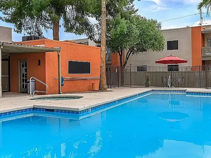 Beautiful apartment courtyard with lush green lawn, mature trees, picnic area, and charming pathway.