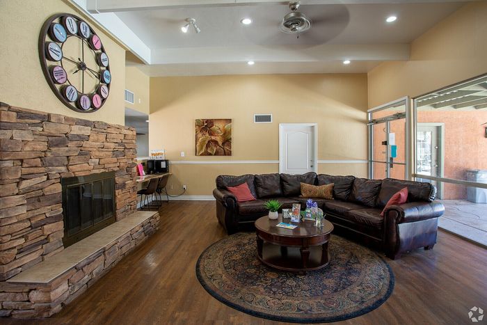 Inviting living room featuring a cozy leather sofa, elegant stone fireplace, and stylish wall clock, perfect for relaxation and entertainment.