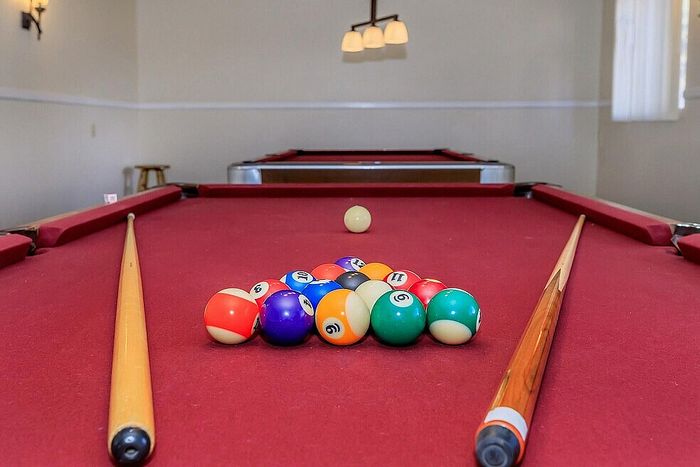 Inviting game room featuring a classic red billiards table with a full set of vibrant balls, perfect for entertaining.