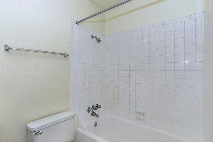 Bright and clean bathroom featuring a classic white bathtub and tiled walls, perfect for relaxation.