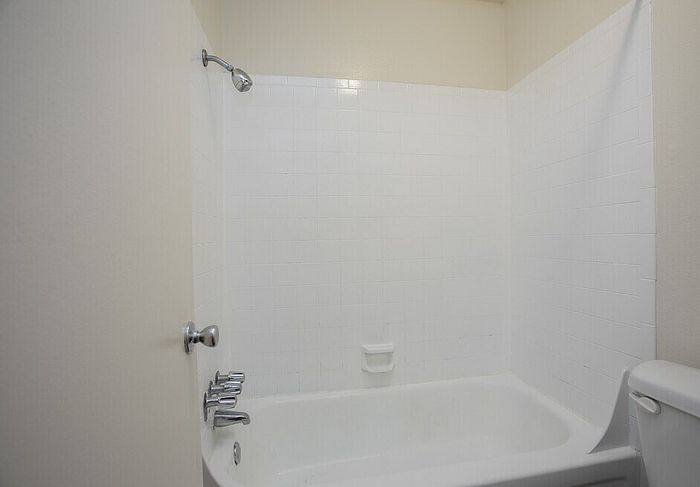 Pristine white bathroom featuring a modern bathtub and polished chrome fixtures.