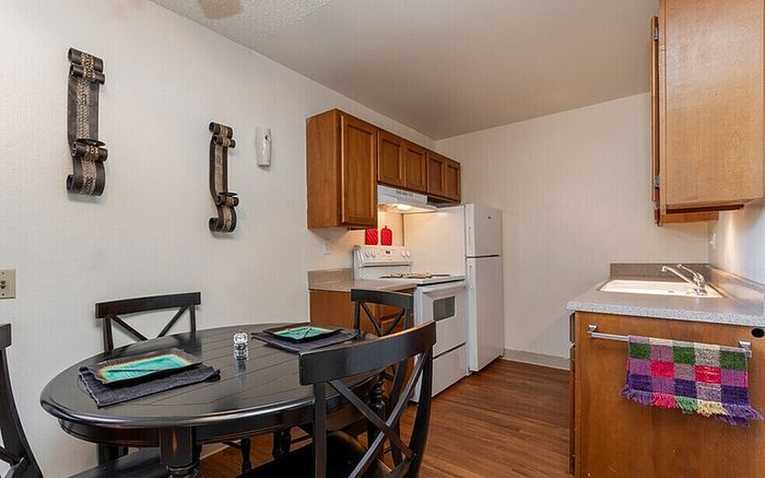 Charming kitchen with warm wooden cabinetry, sleek countertops, and a cozy dining area perfect for home-cooked meals.