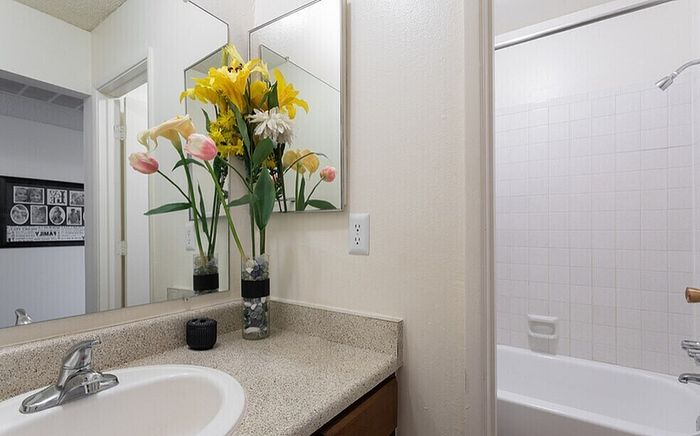 Charming bathroom with elegant flowers on the countertop and a modern bathtub, creating a serene and inviting space.