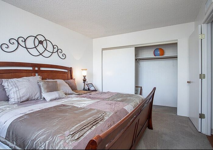 Elegant master bedroom with a plush bed, decorative wall art, and spacious closet, offering a cozy and inviting atmosphere.