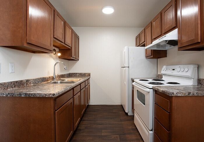 Modern kitchen with elegant wooden cabinets, spacious countertops, and a full range of appliances.