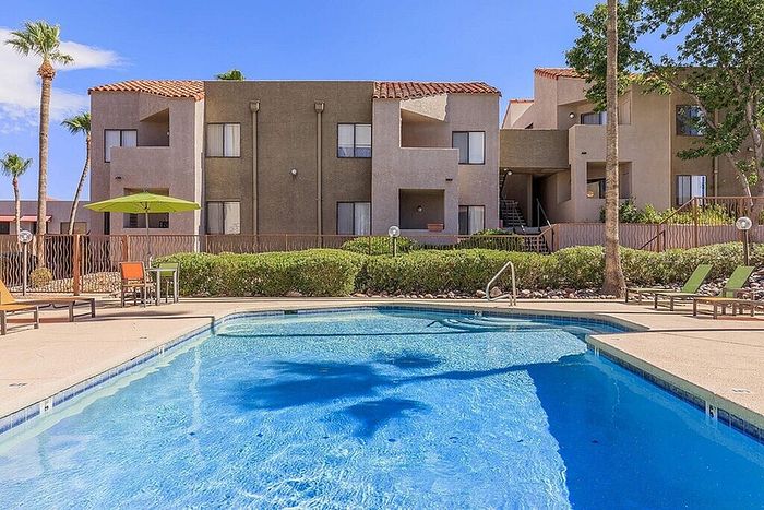 Inviting apartment complex with modern architecture and a refreshing swimming pool, perfect for relaxation and leisure in a sunny setting.