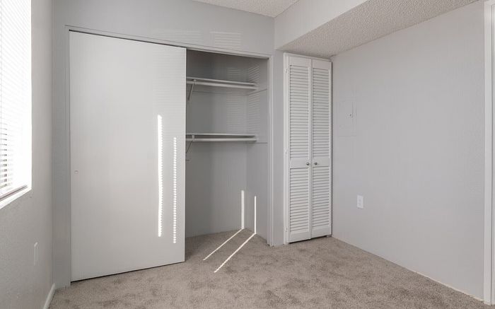 Bright and spacious bedroom featuring a large modern closet with shelving, perfect for ample storage.