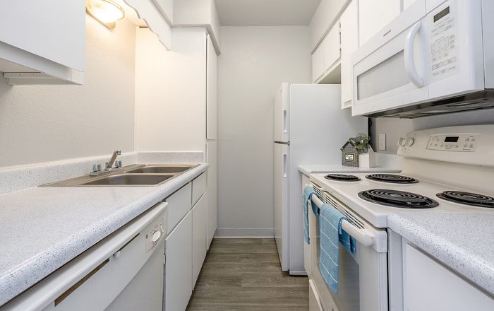 Bright and modern kitchen with sleek white appliances, ample cabinetry, and stylish countertops, perfect for culinary creativity.