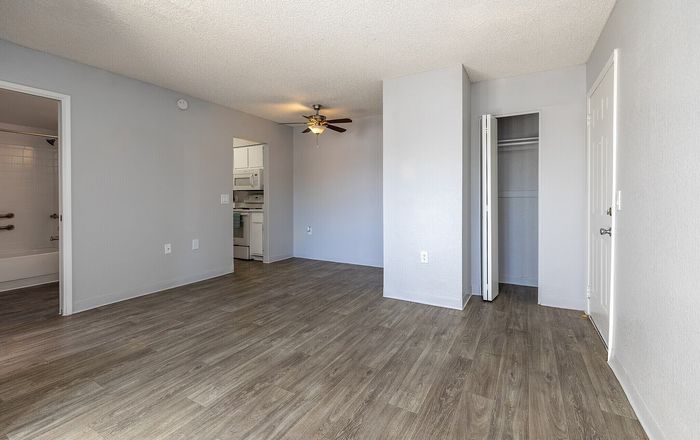 Bright, inviting living space with modern flooring, adjacent to a functional kitchen and cozy bathroom.