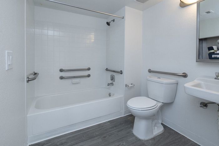 Modern bathroom with sleek fixtures, including a spacious tub, stylish sink, and elegant lighting in a serene, white palette.