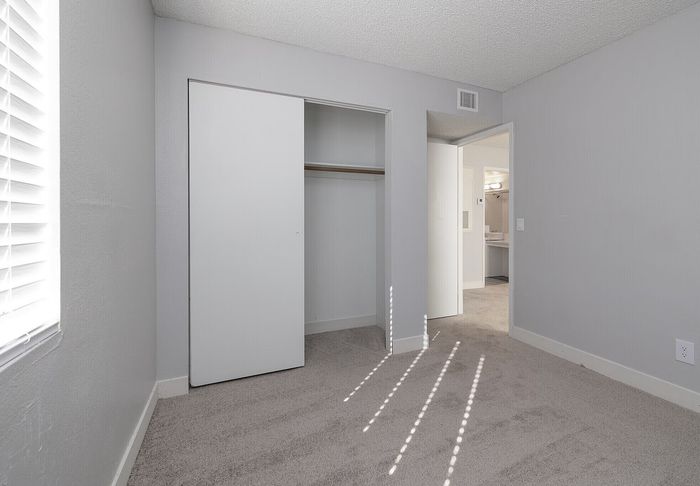 Bright and airy bedroom featuring a spacious closet and soft neutral tones.