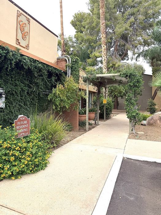 Inviting pathway adorned with lush greenery and vibrant flowers leading to a welcoming entrance, perfect for future residents.