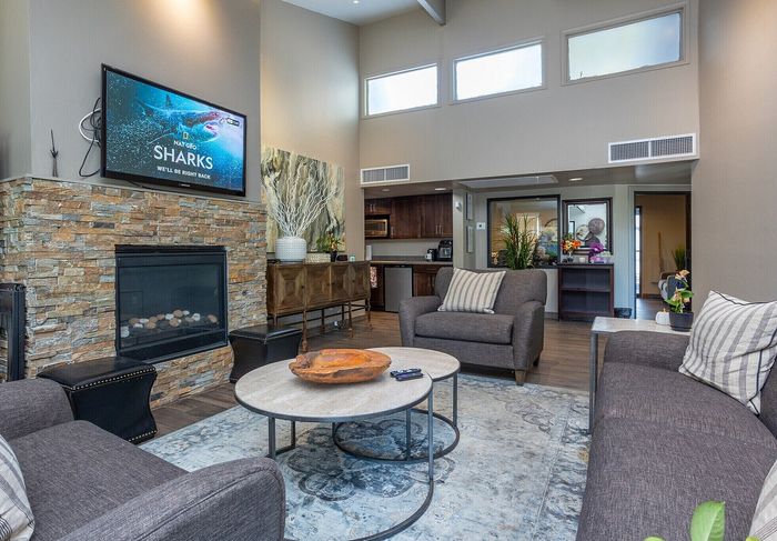 Contemporary living room with high ceilings, stone fireplace, and stylish furnishings creating a cozy atmosphere.