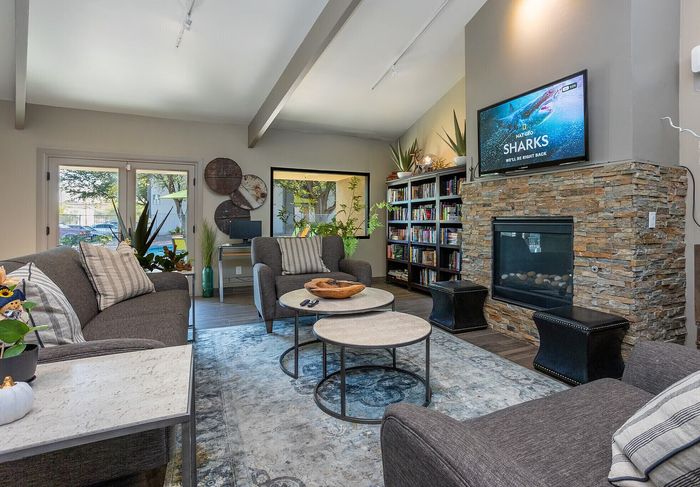 Inviting living room with stylish gray couches, a stone fireplace, and tasteful decor. Perfect for relaxation and entertaining.