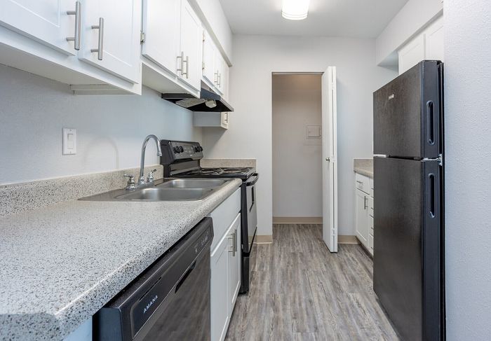 Modern kitchen with sleek countertops, white cabinetry, and stainless steel appliances, offering a perfect blend of style and functionality.