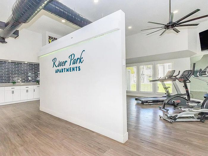 Modern fitness center at River Park Apartments with sleek aerobic equipment and stylish design elements.