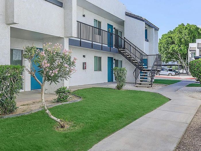 Charming apartment exterior with modern design, vibrant greenery, and inviting walkway.