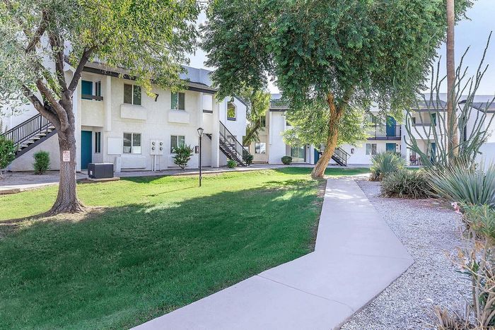 Charming apartment complex nestled in lush greenery with inviting walkways and modern design.