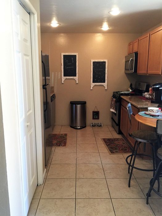 Inviting kitchen with warm wooden cabinetry, sleek stainless steel appliances, and elegant tiled flooring, perfect for culinary creativity and cozy gatherings.