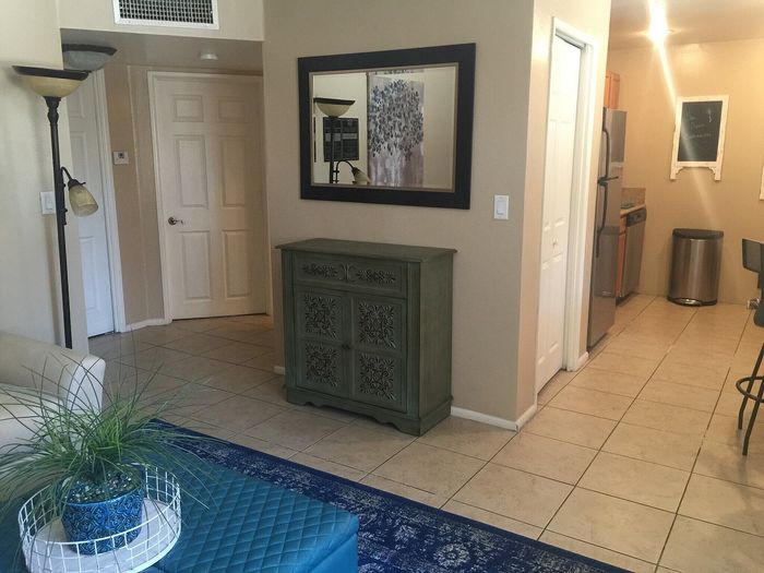 Inviting apartment interior with modern kitchen, stylish tiled flooring, and elegant decor, creating a cozy living space.
