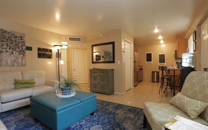 Inviting living space with elegant decor, a plush sofa, modern kitchen, and stylish seating for a cozy atmosphere.