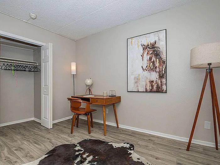 Chic home office space featuring elegant wooden desk, modern art, and cozy lighting, perfect for productive workdays.