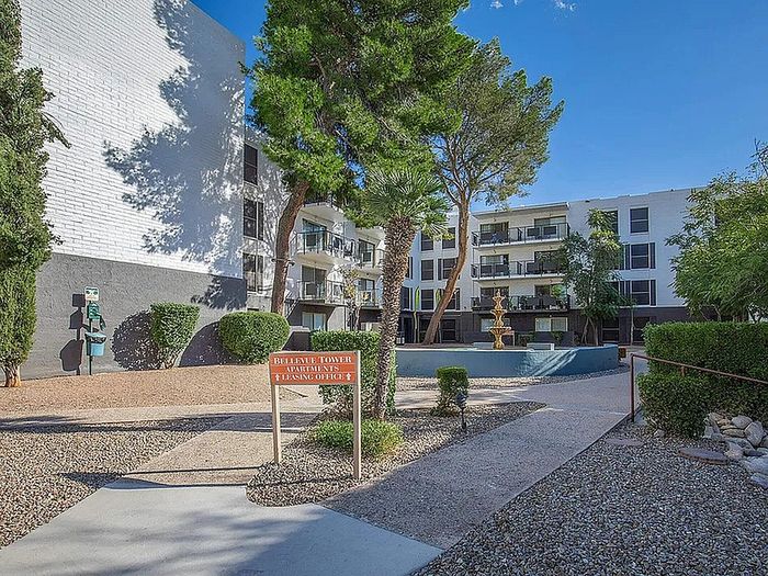 Charming apartment complex with modern architecture, lush greenery, and a picturesque fountain, offering serene living spaces.