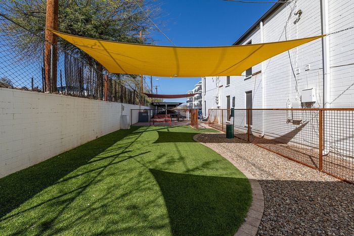 Inviting outdoor area featuring vibrant green artificial turf and sunshade canopies, ideal for relaxation and leisure activities.