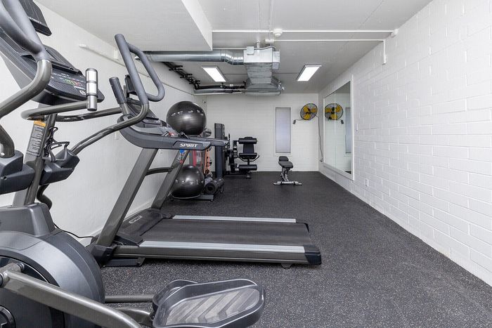 Modern fitness room featuring state-of-the-art cardio equipment and sleek design in apartment complex.