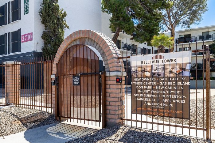 Inviting Bellevue Tower entrance with modern brick archway, featuring amenities like a fitness center, dog park, and gated access for a secure lifestyle.