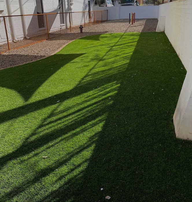 Charming outdoor space with lush green artificial turf and a modern fenced boundary, perfect for relaxation and leisure.