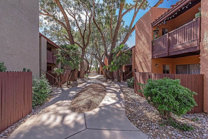 Charming apartment complex with lush greenery, wooden balconies, and vibrant atmosphere.