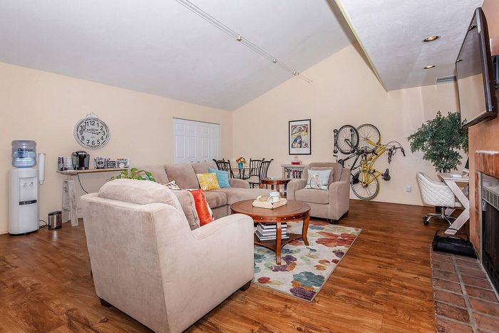 Inviting living room featuring plush beige sofas, stylish wooden floors, and vibrant decor; a cozy space perfect for relaxation and entertaining.